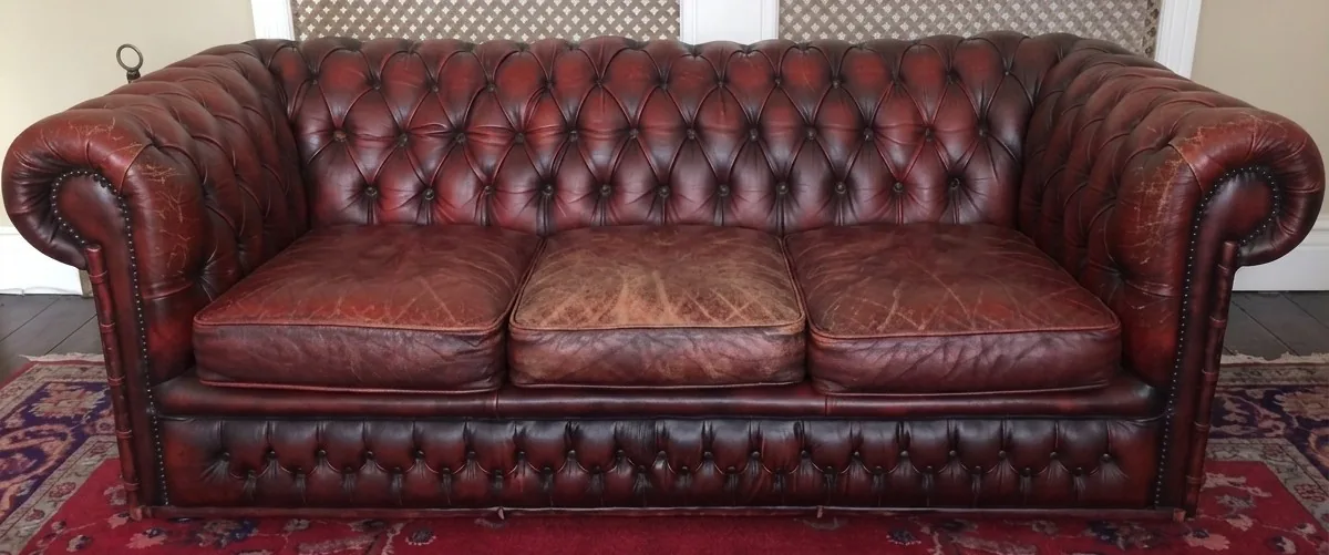 Worn, creased oxblood Chesterfield sofa before restoration